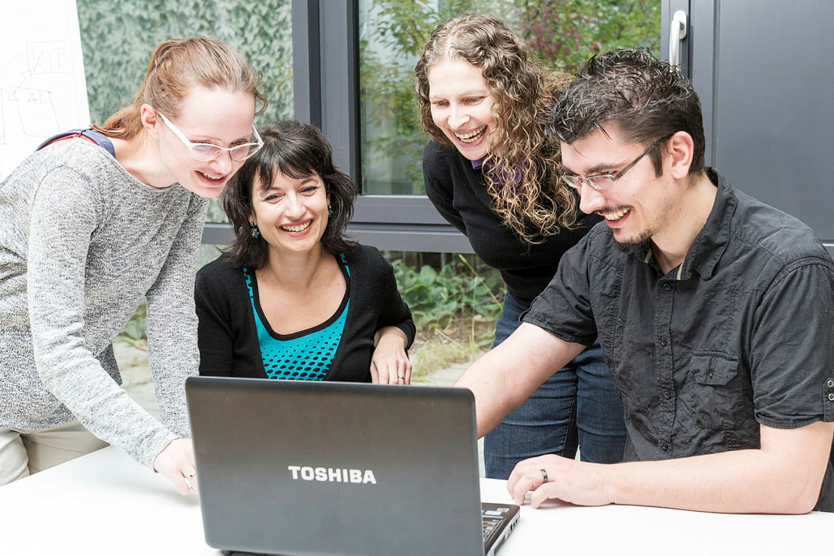 Studierende und Lehrkraft am Rechner