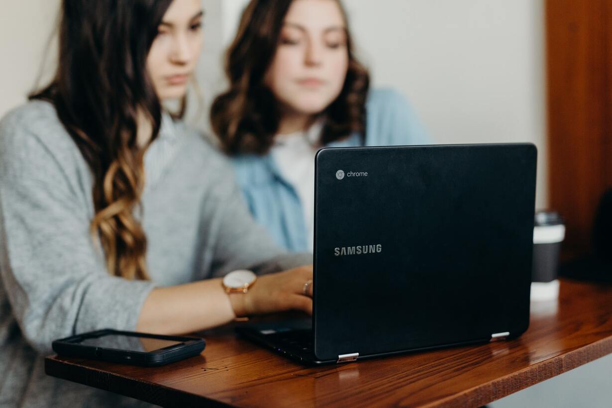 Das Bild zeigt zwei junge Frauen am Laptop.