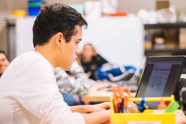 Das Bild zeigt einen jungen Mann am Computer.